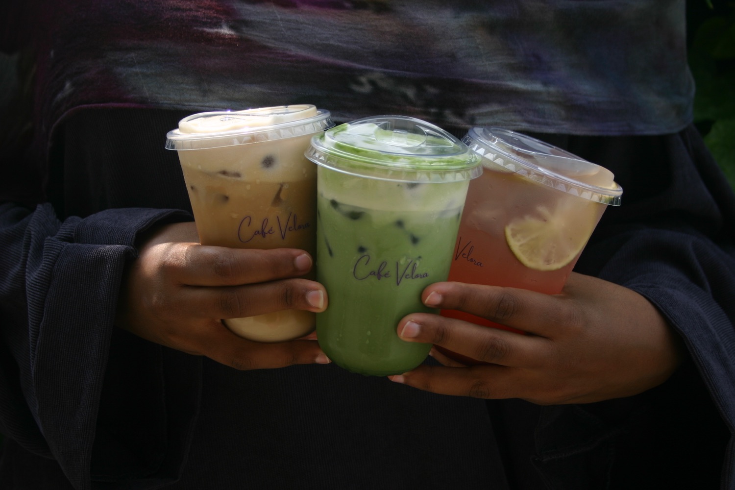 Three Café Velora coffee and matcha drinks at an event